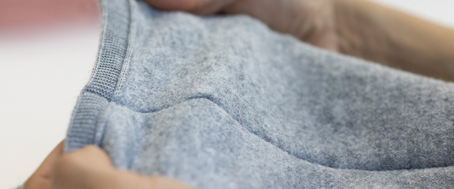 Inspecting the finish of a grey wool garment