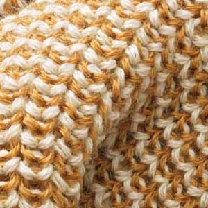 Nahaufnahme eines disana Strickstoffs aus Bio-Merinowolle in Toffee-Natur mit charakteristischen Perlfangmaschen