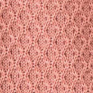Nahaufnahme eines disana Strickstoffs aus Bio-Merinowolle in der Farbe Softpink mit charakteristischem Aran-Muster